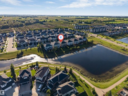 Aerial perspective showcasing residential properties bordering a body of water, surrounded by green spaces and agricultural fields - 5809 65 Street, Beaumont, AB - Outdoor With View