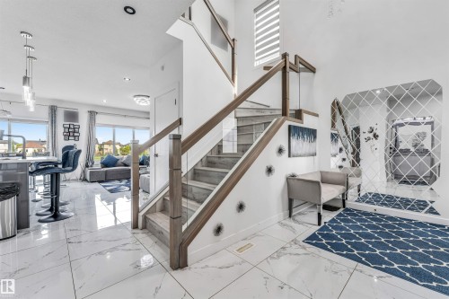 Contemporary staircase featuring wood-finish treads and risers with glass panel railings - 5809 65 Street, Beaumont, AB - Indoor Photo Showing Other Room