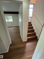Wood-finish flooring throughout, complemented by white baseboards and trim - 