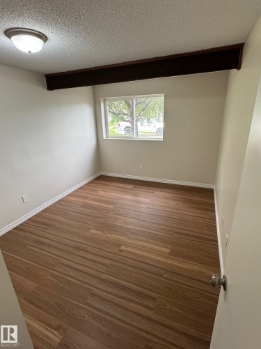 Neutral wall color, wood-finish flooring, white trim, and a window with natural light - 482 Lee Ridge Road Nw, Edmonton, AB 