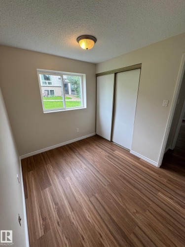 Room featuring wood-finish flooring, a window with exterior views, and a ceiling-mounted light fixture - 482 Lee Ridge Road Nw, Edmonton, AB 
