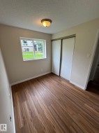Room featuring wood-finish flooring, a window with exterior views, and a ceiling-mounted light fixture - 