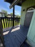 Covered exterior porch with dark-stained wood-finish flooring and matching railing - 482 Lee Ridge Road Nw, Edmonton, AB 