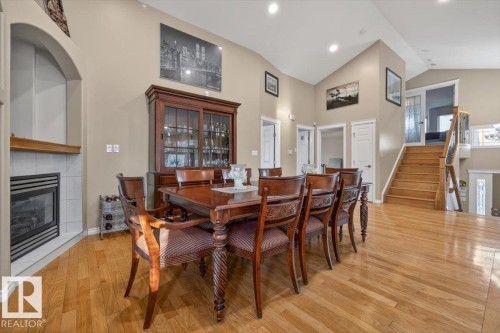 Vaulted ceilings enhance this open space featuring wood-finish flooring - 6050 164A Avenue, Edmonton, AB - Indoor Photo Showing Dining Room With Fireplace