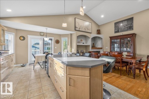 Open-concept kitchen and dining area featuring a vaulted ceiling and a central island with a grey countertop - 6050 164A Avenue, Edmonton, AB - Indoor