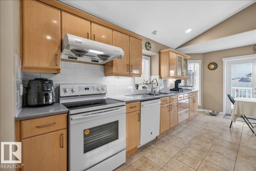 Kitchen featuring light wood cabinetry, white subway tile backsplash, and a ceramic tile floor - 6050 164A Avenue, Edmonton, AB - Indoor Photo Showing Kitchen With Double Sink