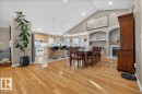 Open-concept living area featuring vaulted ceilings, wood-finish flooring, a kitchen island with seating, a built-in fireplace, and recessed lighting - 6050 164A Avenue, Edmonton, AB  - Indoor Photo Showing Other Room 