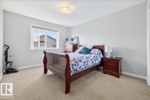 Carpeted room with a ceiling-mounted light fixture, light gray walls, white trim, and a window featuring white casing - 6050 164A Avenue, Edmonton, AB - Indoor Photo Showing Bedroom