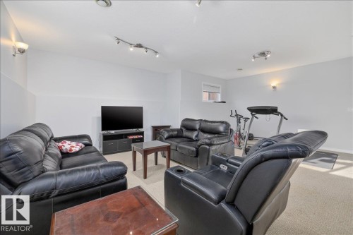 Spacious room featuring neutral carpeting, recessed ceiling lighting, and wall sconces - 6050 164A Avenue, Edmonton, AB - Indoor