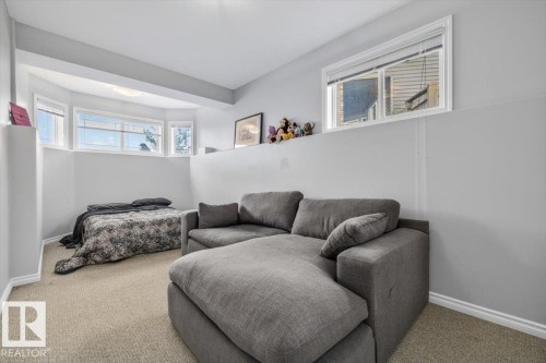 Lower level living area featuring light beige carpeting, white baseboards, and light gray walls - 6050 164A Avenue, Edmonton, AB - Indoor
