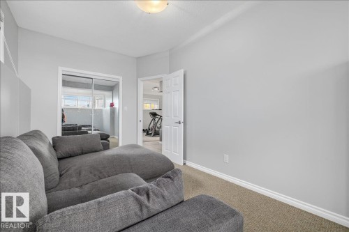 Carpeted room with light gray walls, white trim, a flush-mount ceiling light, and a white door with silver hardware - 6050 164A Avenue, Edmonton, AB - Indoor