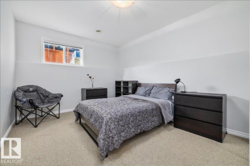 Carpeted room featuring a window with horizontal blinds, white baseboards, a flush-mount ceiling light, and a two-tone wall finish - 6050 164A Avenue, Edmonton, AB - Indoor Photo Showing Bedroom