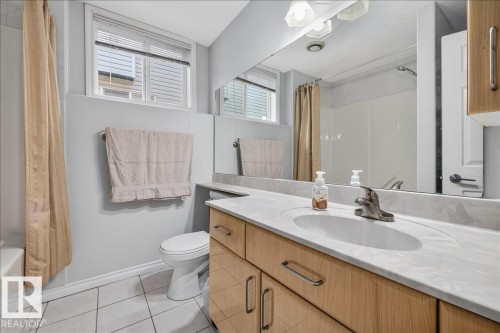 Bathroom featuring a single vanity with wood-finish cabinetry, a white oval undermount sink, and a light-toned countertop - 6050 164A Avenue, Edmonton, AB - Indoor Photo Showing Bathroom