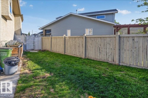 Expansive grass-covered yard featuring a wood privacy fence and a chain link gate - 6050 164A Avenue, Edmonton, AB - Outdoor