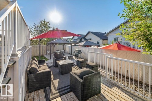 Expansive wood deck with white railings, offering direct access to a paved patio area - 6050 164A Avenue, Edmonton, AB - Outdoor With Deck Patio Veranda