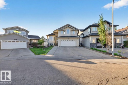 Two-story residence featuring a neutral stucco exterior with dark trim accents and an attached two-car garage - 6050 164A Avenue, Edmonton, AB - Outdoor With Facade