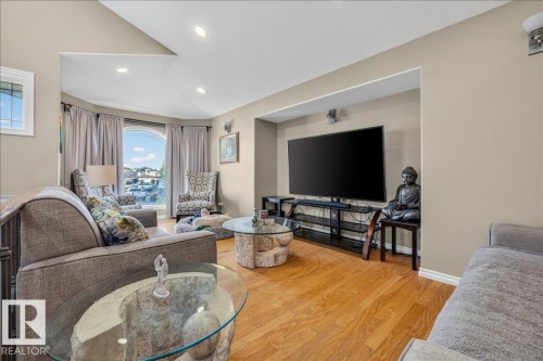 Spacious living area featuring wood-finish flooring, recessed lighting, and a vaulted ceiling - 6050 164A Avenue, Edmonton, AB - Indoor Photo Showing Living Room