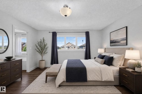 Spacious bedroom featuring wood-finish flooring, a contemporary ceiling light fixture, and a multi-pane window with dark drapery - 1346 Cunningham Drive, Edmonton, AB 