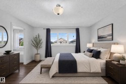 Spacious bedroom featuring wood-finish flooring, a contemporary ceiling light fixture, and a multi-pane window with dark drapery - 