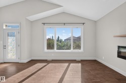 Spacious room featuring vaulted ceilings, a large multi-pane window, and wood-finish tile flooring - 