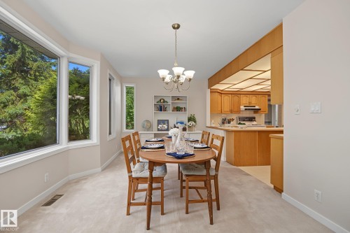 Dining area featuring a bay window, carpet flooring, and a chandelier - 9516 146 Street, Edmonton, AB 