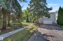 Exterior featuring light blue siding, a white garage door, and a concrete driveway - 9516 146 Street, Edmonton, AB 