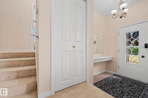 Entryway featuring a decorative transom window, built-in floating console, and tile flooring - 9516 146 Street, Edmonton, AB 