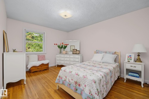 Room featuring wood-finish flooring, a double-hung window, and a ceiling-mounted light fixture - 9516 146 Street, Edmonton, AB 