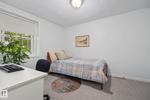 Room with light gray wall paint, a window featuring a roller shade, and gray carpet flooring - 9516 146 Street, Edmonton, AB 