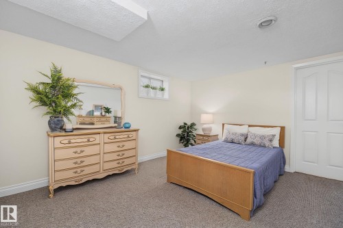 Carpeted room featuring light beige walls and white trim - 9516 146 Street, Edmonton, AB 