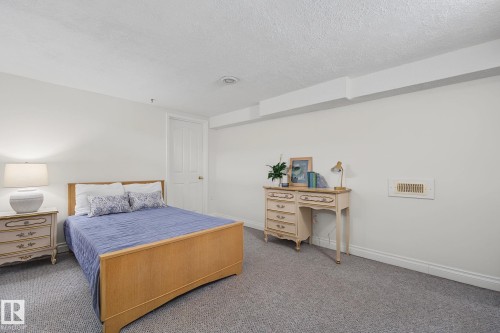 Bedroom featuring light gray walls, textured ceiling, and gray carpeting - 9516 146 Street, Edmonton, AB 