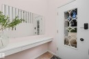 Entryway featuring a white door with decorative glass inlay, an integrated smart lock system, a floating console with drawer storage, a large wall-mounted mirror, and tile flooring - 9516 146 Street, Edmonton, AB 
