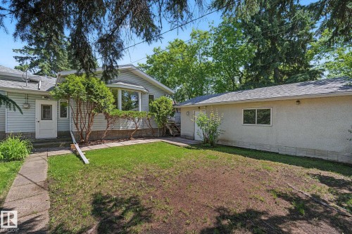 Exterior features include a bay window, a concrete walkway, established shrubs, and a detached structure - 9516 146 Street, Edmonton, AB 