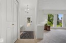 Entryway featuring a decorative glass panel front door, overhead chandelier, and a built-in desk area - 9516 146 Street, Edmonton, AB 