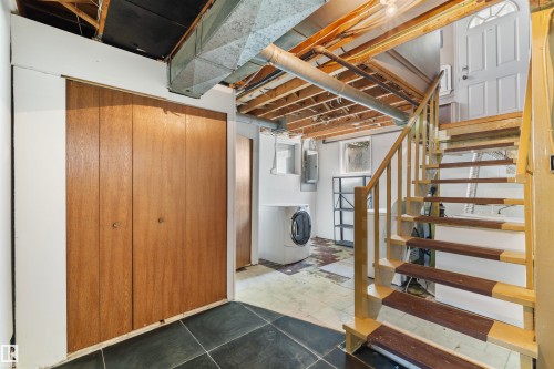 Staircase featuring wood risers and handrail, leading to an exterior door - 10607 73 Ave, Edmonton, AB 