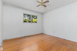 Room featuring a multi-pane window, wood-finish flooring, and a ceiling fan with integrated lighting - 