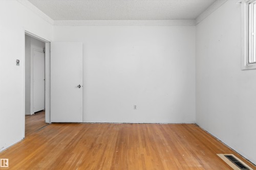 Room with wood-finish flooring, white painted walls, and a window for natural light - 11619 123 Street, Edmonton, AB 