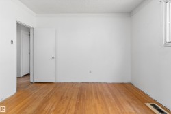 Room with wood-finish flooring, white painted walls, and a window for natural light - 