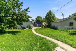 Expansive green lawn with a curved concrete pathway leading to the rear of the property - 