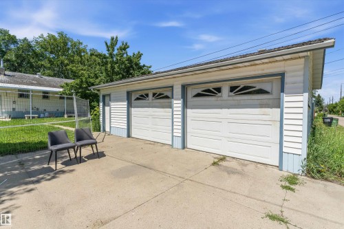 Two-car detached garage with white paneled doors, decorative transom windows, and blue trim - 11619 123 Street, Edmonton, AB 
