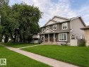 Two-story residence featuring composite siding, white trim, and a stone-clad porch with columns - Front Lawn was rendered - 8530 76 Avenue, Edmonton, AB 