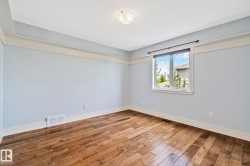 Room with wood-finish flooring, white baseboards, and light blue walls - 