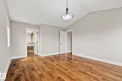 Spacious room featuring wood-finish flooring, vaulted ceiling, and recessed window - 