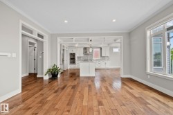 Open-concept living area featuring wood-finish flooring, recessed lighting, and a white trim package - 