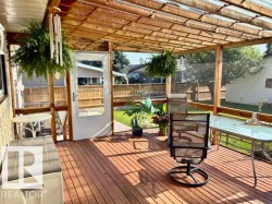 Covered wooden deck with slatted ceiling and translucent panels, featuring a full-light exterior door - 