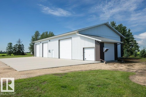 White metal-sided outbuilding with multiple overhead doors - 25023 Twp Rd 612, Rural Westlock County, AB 