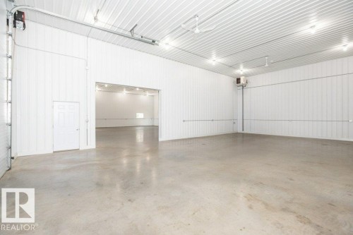Large open room featuring concrete flooring and white corrugated panel walls - 25023 Twp Rd 612, Rural Westlock County, AB 