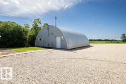 Quonset hut structure featuring corrugated metal siding and a white entry door - 