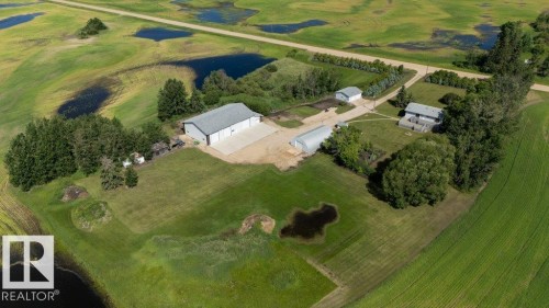 Expansive property featuring multiple outbuildings, a main residence, and varied terrain with natural water features - 25023 Twp Rd 612, Rural Westlock County, AB 