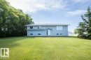 Split-level residence featuring light blue siding, a gray shingle roof, and multiple windows - 25023 Twp Rd 612, Rural Westlock County, AB 